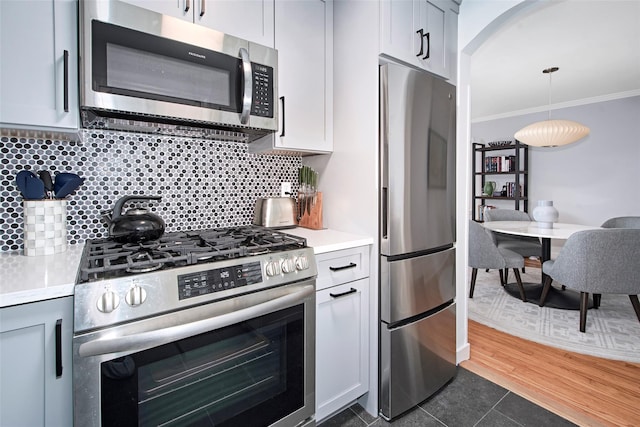4 Peck Unit 47A, Rye, NY 10580 - kitchen with appliances with stainless steel finishes, light countertops, tasteful backsplash, crown molding, and dark tile patterned floors