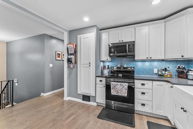 209 Laurel Dr, Cortlandt Manor, NY 10567 - kitchen featuring appliances with stainless steel finishes, baseboards, dark countertops, light wood-type flooring, and recessed lighting