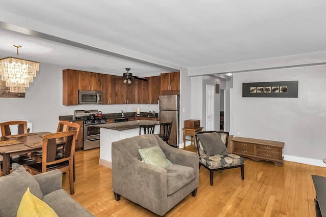 12427 Flatlands Ave Unit 1A, Brooklyn, NY 11208 - living area with a chandelier, light wood-type flooring, a ceiling fan, and baseboards