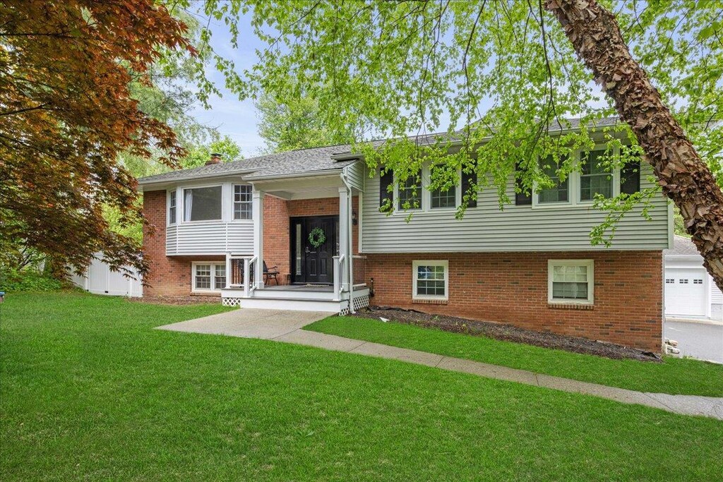 36 Birch Dr, Brewster, NY 10509 - raised ranch featuring brick siding, a front lawn, a garage, and a chimney