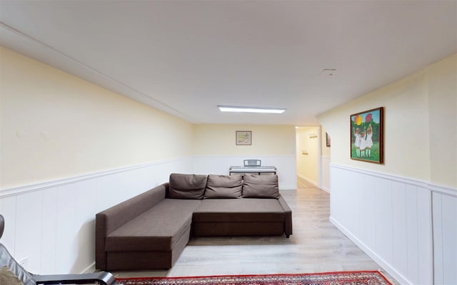 9 Chapel Rd, Newburgh, NY 12550 - living area with light wood-style flooring, a wainscoted wall, and a decorative wall