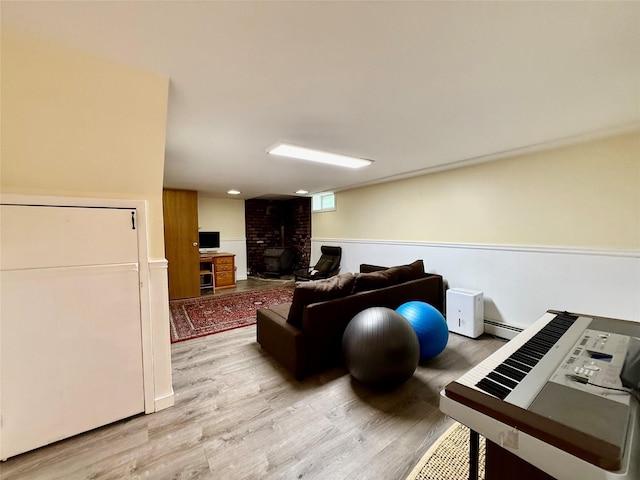 9 Chapel Rd, Newburgh, NY 12550 - living room featuring light wood finished floors, wainscoting, a brick fireplace, and a baseboard radiator