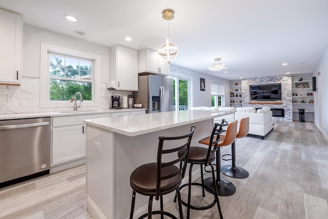 5 Teramar Way, White Plains, NY 10607 - kitchen with stainless steel appliances, a sink, a breakfast bar area, light stone counters, and healthy amount of natural light