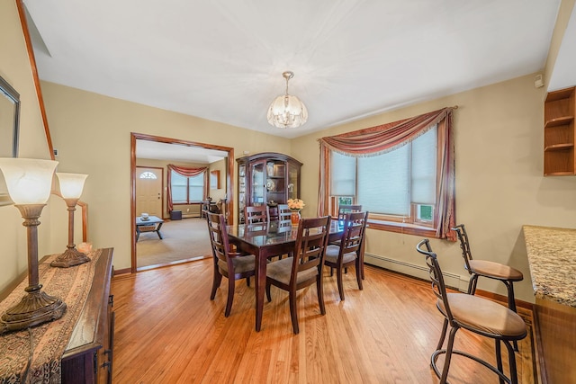 79-48 67th Rd, Middle Village, NY 11379 - dining area with a chandelier, light wood finished floors, baseboard heating, and baseboards