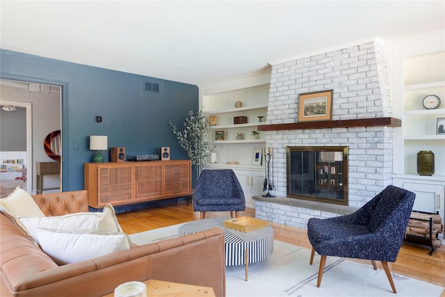 135 Turk Hill Rd, Carmel, NY 10509 - living room featuring built in shelves, wood finished floors, and a fireplace