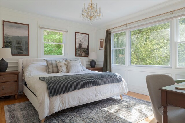 135 Turk Hill Rd, Carmel, NY 10509 - bedroom with wood finished floors, multiple windows, a chandelier, and a decorative wall