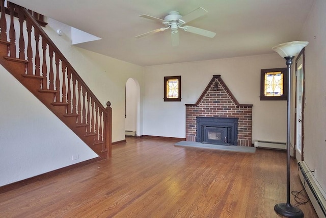 3 Byram Ridge Rd S, Armonk, NY 10504 - unfurnished living room featuring a baseboard heating unit, ceiling fan, wood finished floors, and a brick fireplace
