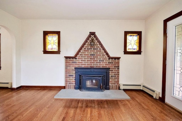 3 Byram Ridge Rd S, Armonk, NY 10504 - unfurnished living room with wood finished floors, baseboard heating, plenty of natural light, and a wood stove