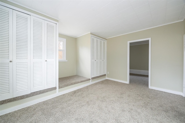 11-13 Eldridge Ln, Red Hook, NY 12571 - unfurnished bedroom with ornamental molding, two closets, carpet floors, and baseboards