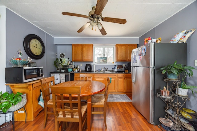 11-13 Eldridge Ln, Red Hook, NY 12571 - kitchen featuring stainless steel appliances, a sink, dark countertops, brown cabinets, and light wood-style floors