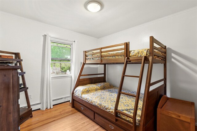 658 Northville Tpke, Riverhead, NY 11901 - bedroom with light wood finished floors, crown molding, and a baseboard heating unit