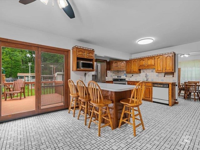 708 Kirbytown Rd, Middletown, NY 10940 - kitchen featuring stainless steel appliances, a sink, brown cabinets, light countertops, and a peninsula