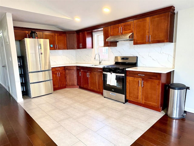 19623 56th Ave, Fresh Meadows, NY 11365 - kitchen featuring stainless steel appliances, under cabinet range hood, light countertops, vaulted ceiling, and light wood-style flooring