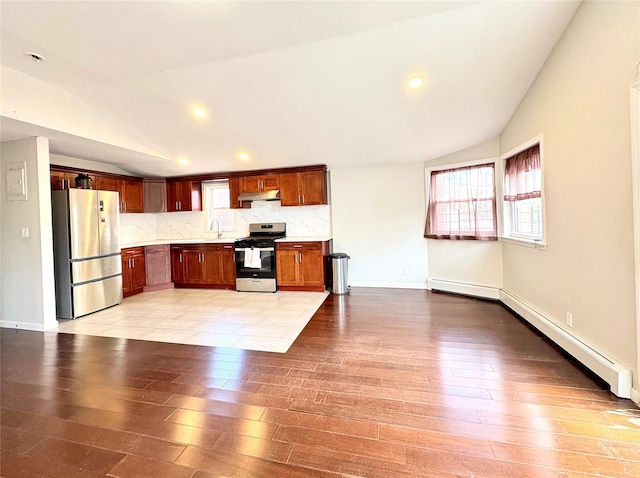 19623 56th Ave, Fresh Meadows, NY 11365 - kitchen featuring appliances with stainless steel finishes, vaulted ceiling, healthy amount of natural light, light wood-style flooring, and under cabinet range hood