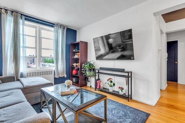 88-01 35th Ave Unit 5F, Jackson Heights, NY 11372 - living room with radiator heating unit, wood finished floors, and baseboards