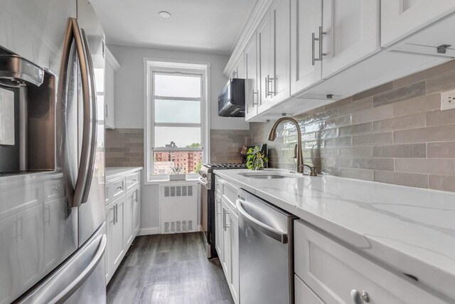 88-01 35th Ave Unit 5F, Jackson Heights, NY 11372 - kitchen featuring appliances with stainless steel finishes, a sink, white cabinetry, and tasteful backsplash