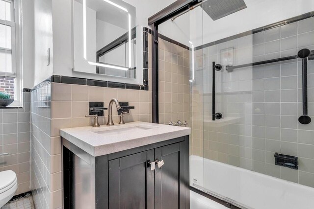 88-01 35th Ave Unit 5F, Jackson Heights, NY 11372 - full bathroom with tile walls, toilet, vanity, and tub / shower combination