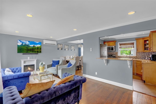 405 Miller Ave, Freeport, NY 11520 - living area with a wall mounted AC, wood finished floors, recessed lighting, crown molding, and a glass covered fireplace