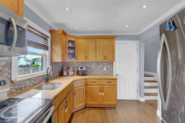 405 Miller Ave, Freeport, NY 11520 - kitchen with appliances with stainless steel finishes, light wood finished floors, a sink, light stone countertops, and ornamental molding