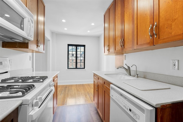 66 Milton Rd Unit C42, Rye, NY 10580 - kitchen with white appliances, a sink, baseboards, brown cabinetry, and recessed lighting