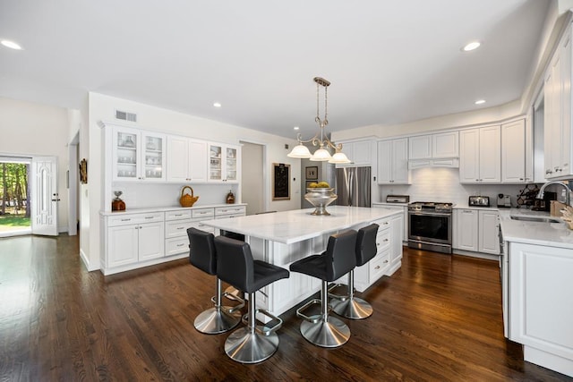 31 Inlet View Path, East Moriches, NY 11940 - kitchen with appliances with stainless steel finishes, a sink, a kitchen island, light countertops, and white cabinets