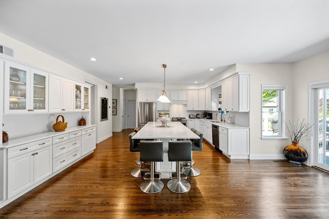 31 Inlet View Path, East Moriches, NY 11940 - kitchen with appliances with stainless steel finishes, white cabinetry, a breakfast bar area, light countertops, and dark wood-type flooring