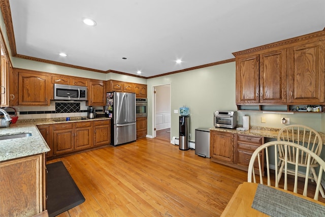 123 E St, South Salem, NY 10590 - kitchen with appliances with stainless steel finishes, brown cabinetry, tasteful backsplash, crown molding, and light stone countertops