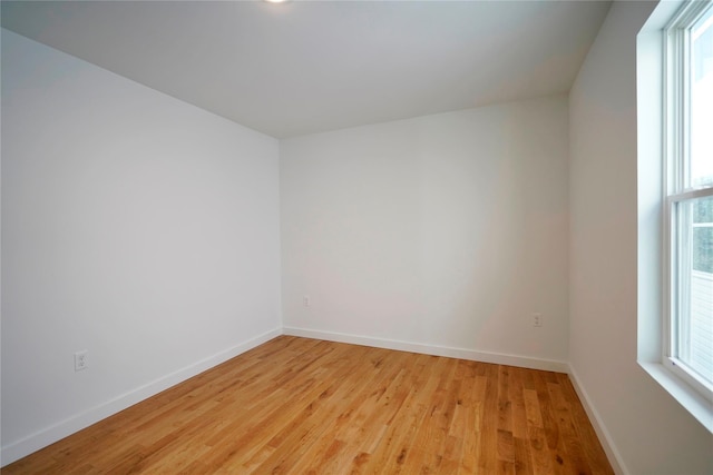 spare room featuring light wood finished floors and baseboards
