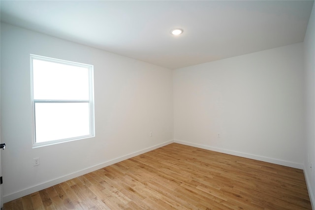 unfurnished room with light wood finished floors, baseboards, and recessed lighting
