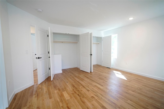 unfurnished bedroom with light wood-type flooring, baseboards, and recessed lighting