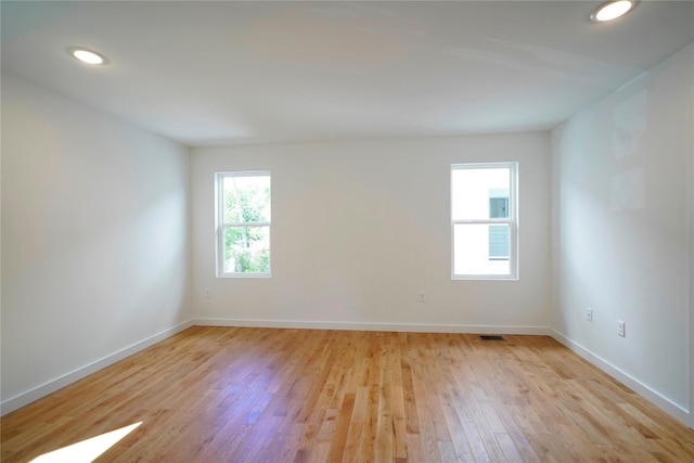 empty room featuring light wood-style flooring, baseboards, and recessed lighting