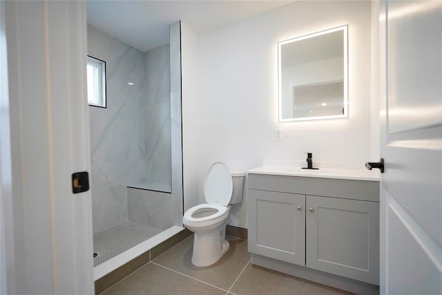 full bathroom with toilet, vanity, tile patterned flooring, and walk in shower