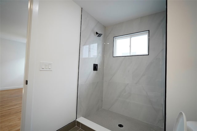 bathroom featuring tiled shower and wood finished floors