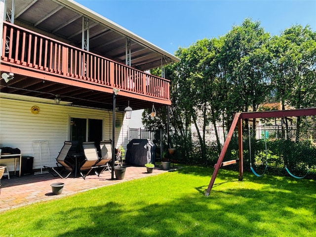 view of yard featuring a patio, a wooden deck, and a playground