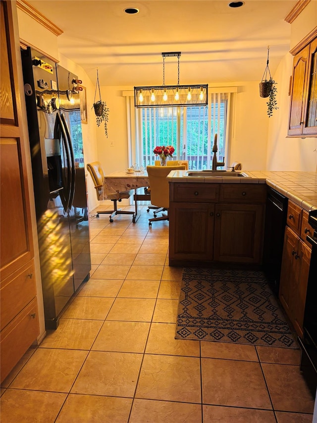 kitchen featuring black appliances, tile countertops, healthy amount of natural light, and light tile patterned floors