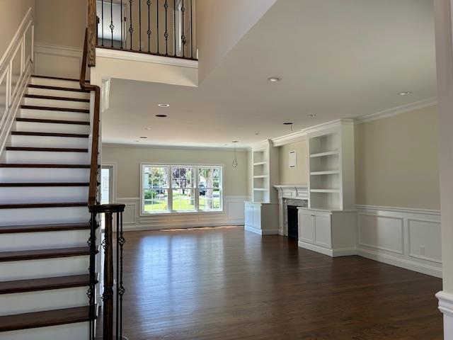 110B Louis St, Massapequa, NY 11758 - unfurnished living room featuring a decorative wall, stairway, wood finished floors, crown molding, and built in features