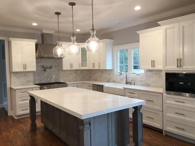 110B Louis St, Massapequa, NY 11758 - kitchen with wall chimney exhaust hood, a sink, a breakfast bar area, white cabinets, and recessed lighting