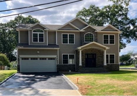 110B Louis St, Massapequa, NY 11758 - craftsman house featuring driveway, a garage, a front yard, and stone siding