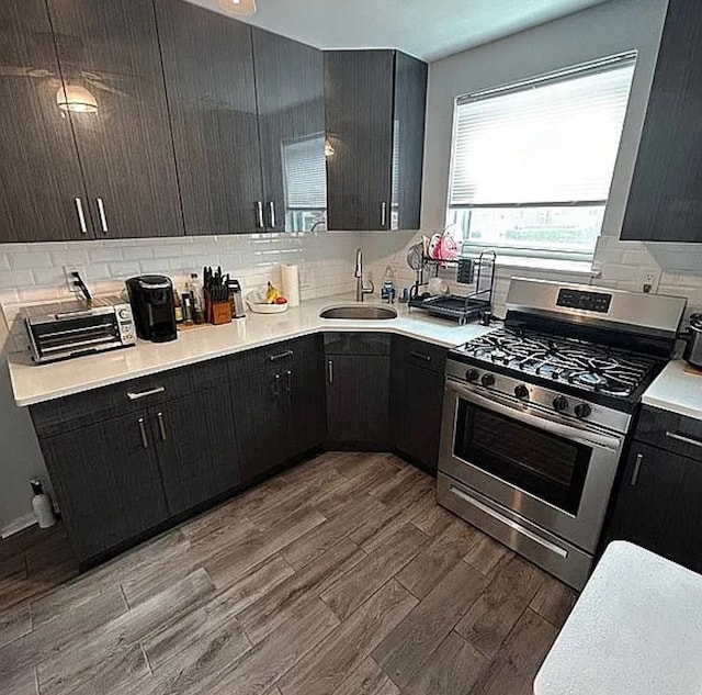 264-17 Langston Ave Unit E-2, Glen Oaks, NY 11004 - kitchen featuring stainless steel gas stove, a sink, wood finished floors, tasteful backsplash, and light countertops