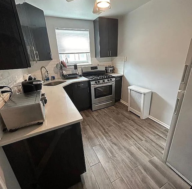 264-17 Langston Ave Unit E-2, Glen Oaks, NY 11004 - kitchen featuring stainless steel gas range, a sink, dark cabinetry, and wood finished floors