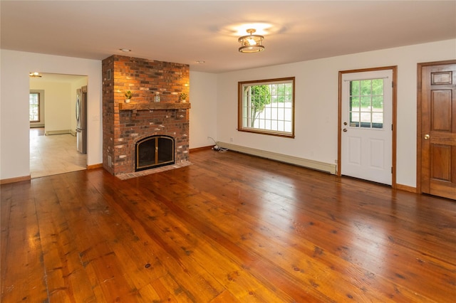 162 Lippincott Rd, Wallkill, NY 12589 - unfurnished living room with baseboard heating, hardwood / wood-style floors, and a brick fireplace