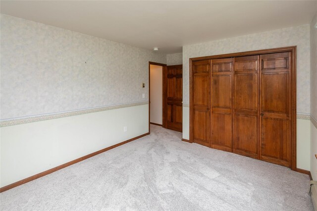 162 Lippincott Rd, Wallkill, NY 12589 - unfurnished bedroom with wallpapered walls, light colored carpet, and a closet