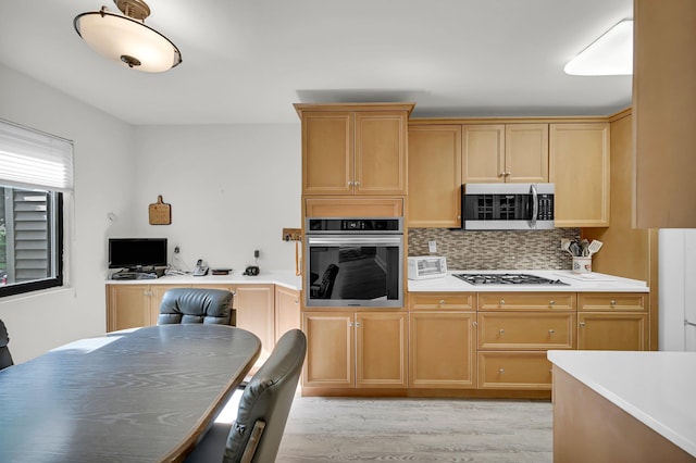 48 Old Lake Rd, Congers, NY 10920 - kitchen featuring appliances with stainless steel finishes, light countertops, decorative backsplash, a desk, and light wood-style floors