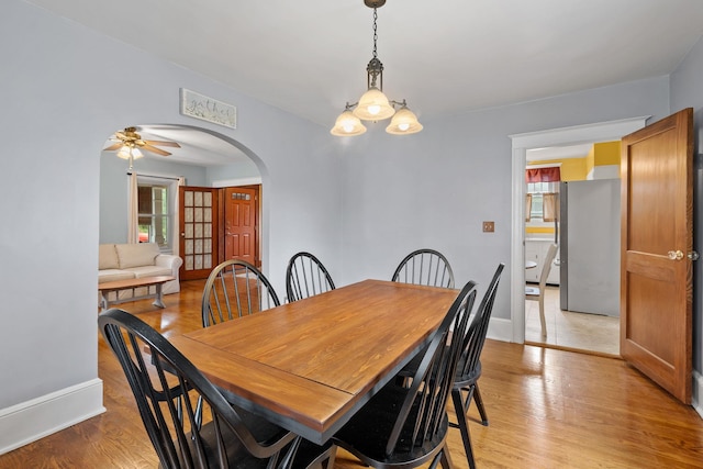 323 Hooker Ave, Poughkeepsie, NY 12603 - dining space featuring arched walkways, light wood-style floors, a chandelier, baseboards, and ceiling fan