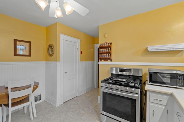 323 Hooker Ave, Poughkeepsie, NY 12603 - kitchen featuring stainless steel appliances, wainscoting, ceiling fan, light countertops, and light tile patterned floors
