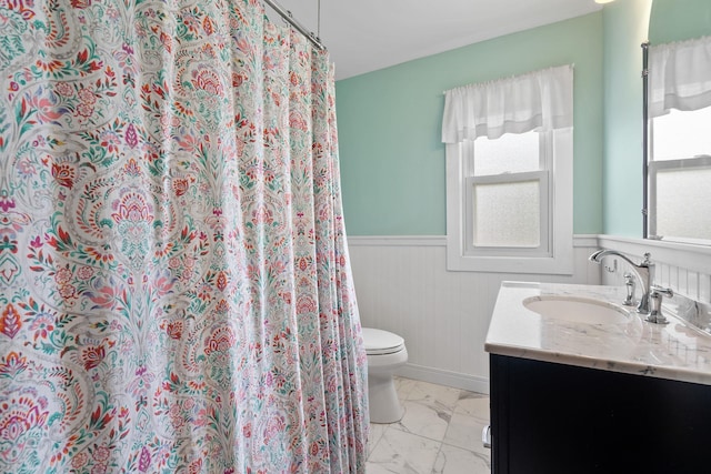 323 Hooker Ave, Poughkeepsie, NY 12603 - bathroom with marble finish floors, toilet, wainscoting, and vanity