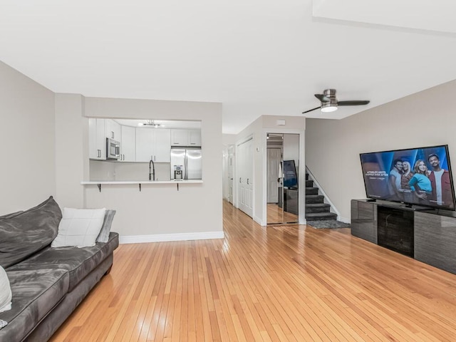 117 Sunset Blvd Unit 10117, Bronx, NY 10473 - living room featuring light wood-type flooring, baseboards, stairway, ceiling fan, and a chandelier