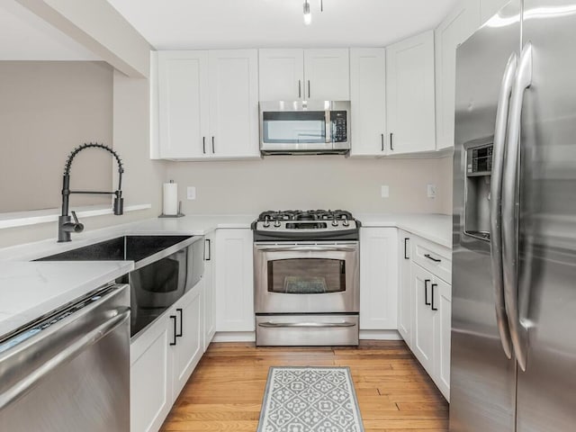 117 Sunset Blvd Unit 10117, Bronx, NY 10473 - kitchen featuring stainless steel appliances, light countertops, white cabinetry, and a sink