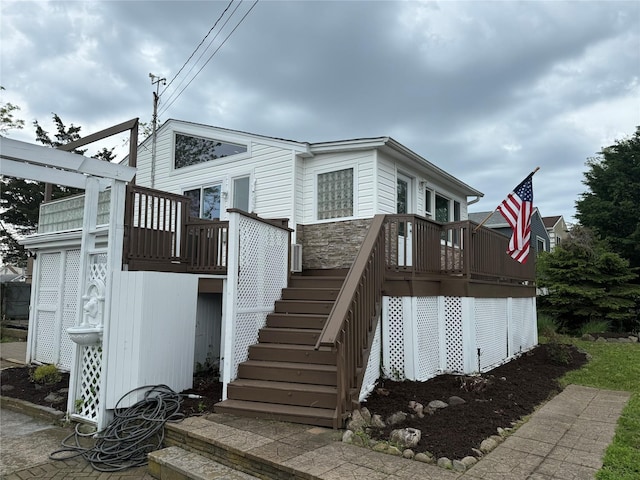 812 Beach St, Lindenhurst, NY 11757 - view of property exterior featuring stairway, a deck, and stone siding