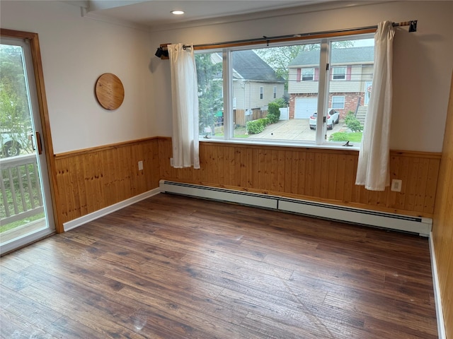 812 Beach St, Lindenhurst, NY 11757 - unfurnished room featuring a baseboard radiator, a wainscoted wall, wood walls, and wood finished floors